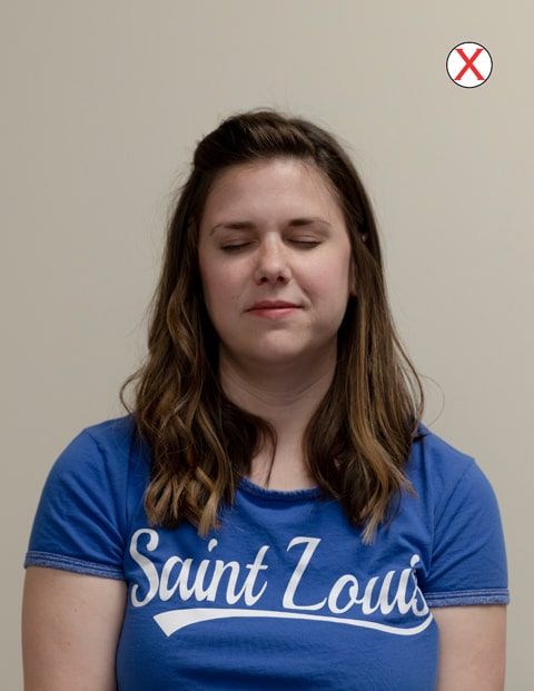A headshot of a woman wearing a SLU t-shirt. Her eyes are closed.
