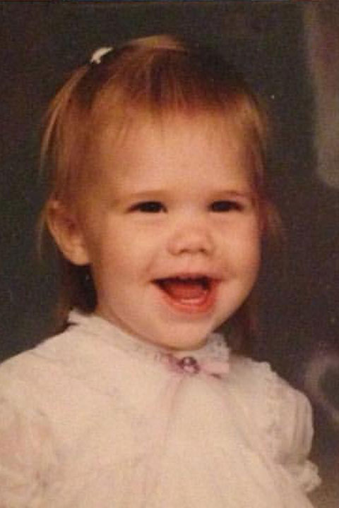 A headshot of a young toddler smiling at the camera.